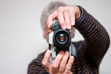A man takes a photo with a retro camera