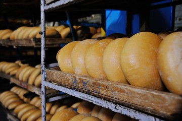 many loaves of fresh bread on a shelf in a bakery