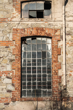 Glass iron window of old grunge abandoned vintage industrial building