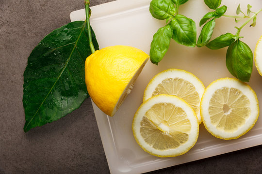 Fresh ripe lemons on dark stone background and basil . chef knife.Top view with copy space
