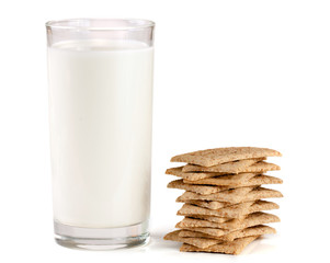 glass of milk with stack of grain crispbreads isolated on white background