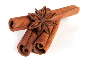 three cinnamon sticks with star anise isolated on white background