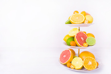 Different citrus fruit on cake stand with copy space