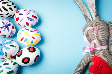 Easter bunny on a blue background. Rabbit. Easter ideas. Easter eggs. Space for text. Black lettering on a heart happy easter.