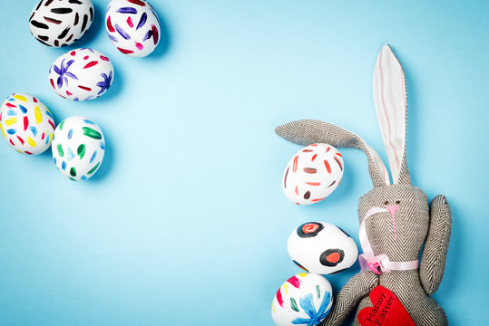 Easter bunny on a blue background. Rabbit. Easter ideas. Easter eggs. Space for text. Black lettering on a heart happy easter.