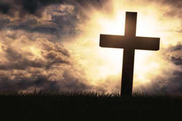 Silhouette of cross symbol on grass