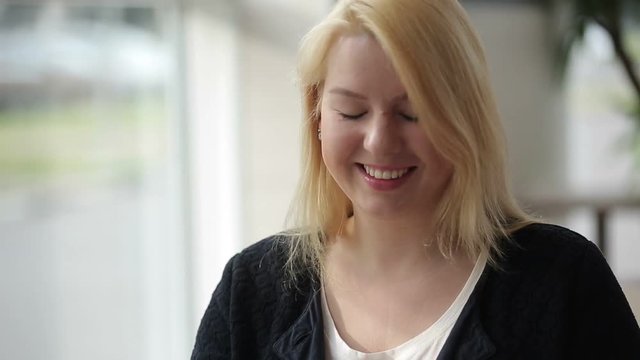 Young blonde woman smiling and looking down