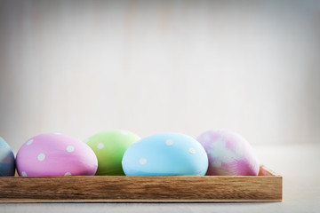Pastel Easter eggs on wooden table.