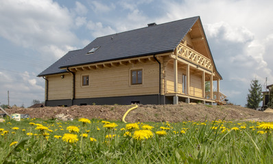 Fototapeta na wymiar building of a wooden house on a meadow covered