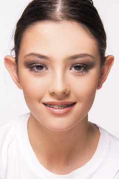 girl with brace smiling on white