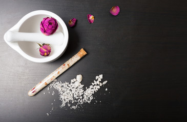 Cosmetics and flowers on a black background