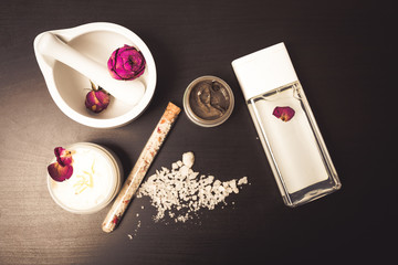 Cosmetics and flowers on a black background