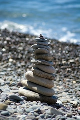 Tower of sea pebbles on the background of the sea.