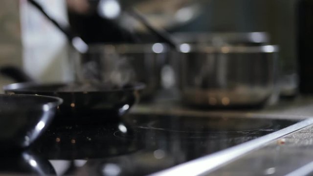 Close-up of chef hands preparing pancakes on pan in kitchen