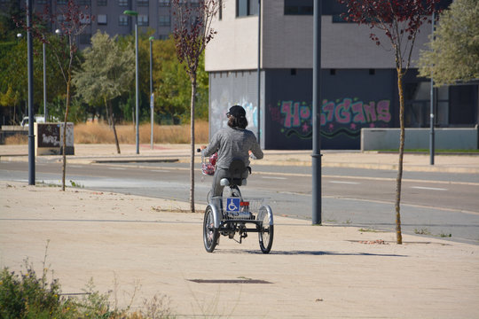 mujer circulando con una bicicleta adaptada