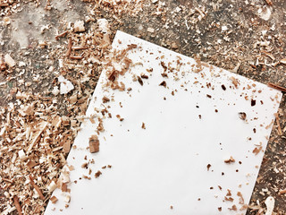 Blank paper on wooden table with sawdust top view