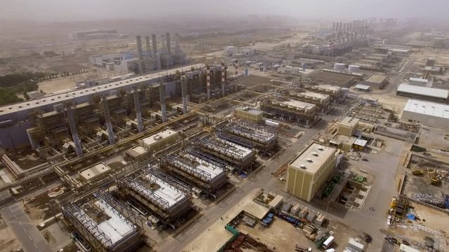 aerial view of a huge power plant with pipes, hangars and workshops in Dubai, UAE