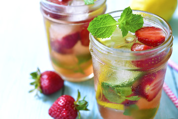 Strawberry lemonade with lemon and mint in a mason jar .
