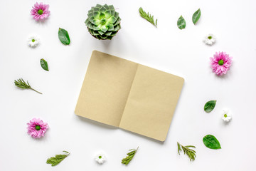 Notebook with flower petals on white table background top view mock-up