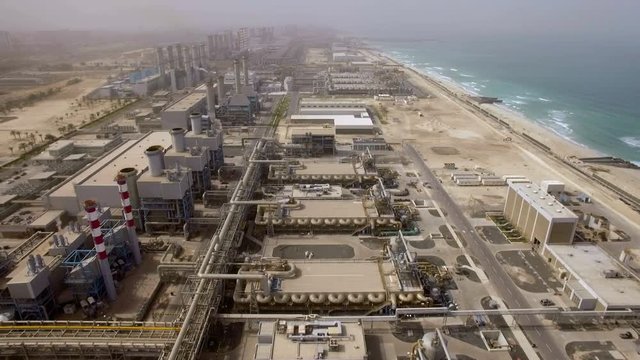 Aerial view of a huge power plant on the shore of the sea in Dubai, UAE