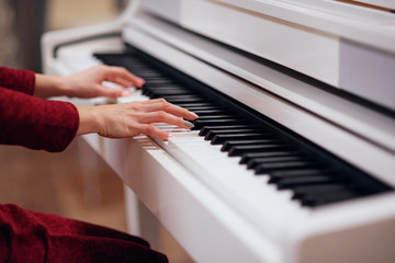 Obraz premium Pianist playing on a white piano. Hands close up.