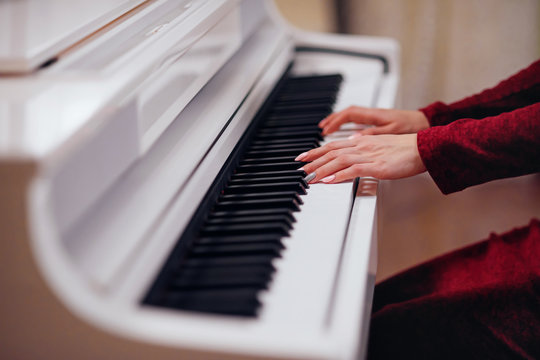 Pianist playing on a white piano. Hands close up.