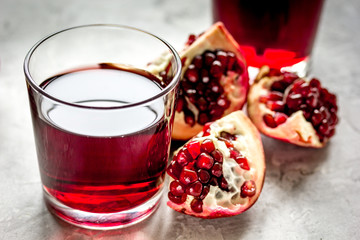 fresh pomegranate with juice in glasses on kitchen background