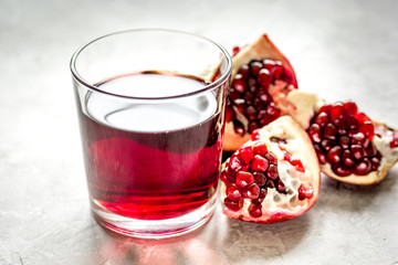 pomegranate juice with seed on stone table background