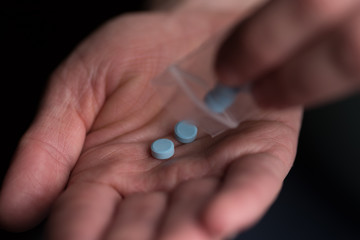 woman pouring out pills from a bag into her hand