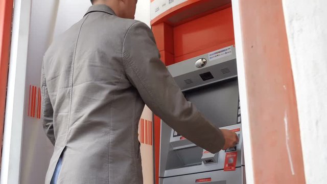 Man withdraw cash from ATM.

