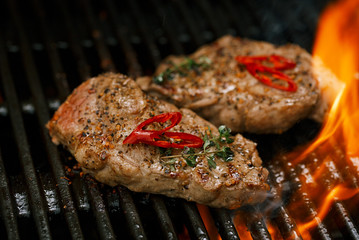 pork steak on bbq grill with flame