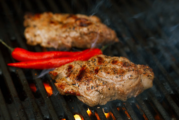 pork steak on bbq grill with flame