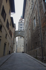 Ancient street and Campanile del Duomo di Pistoia on background. Tuscany. Italy.