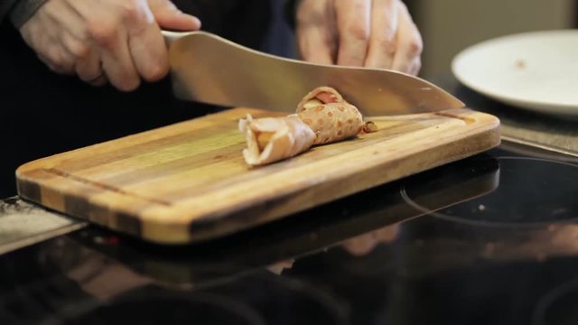 Chef cutting hot cooked pancakes on a board