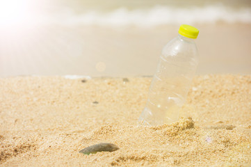 Bottle emtry on the sand behind beach with sunlight.