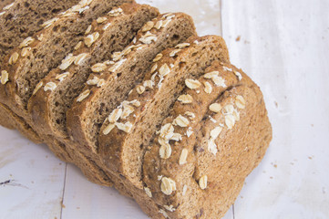 Fresh whole grain bread on white wood background