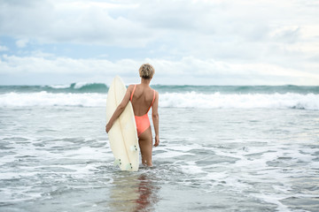 Fototapeta premium Blonde with surfboard on beach