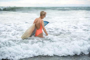 Blonde with surfboard on beach