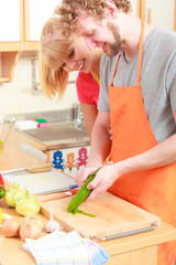 Obraz na płótnie Canvas Couple preparing vegetables salad peeling cucumber