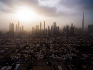 Naklejka na ściany i meble epic aerial view of the urban landscape, with large skyscrapers and the sun breaking through the clouds. Dubai, UAE