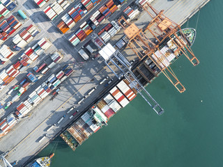 the container vessel is opening hatch cover to transition cargo of loading and discharging cargo in port alongside, aerial view