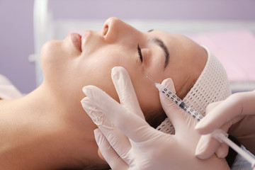 Obraz na płótnie Canvas Young beautiful woman receiving facial injections in salon