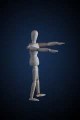 Wooden figurine stretching arms forward in zombie pose on dark background