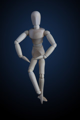Wooden figurine crossing legs in elegant dancing move on dark background