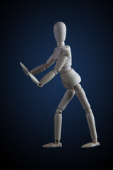 Wooden figurine in elegant dance move on dark background with blue spotlight