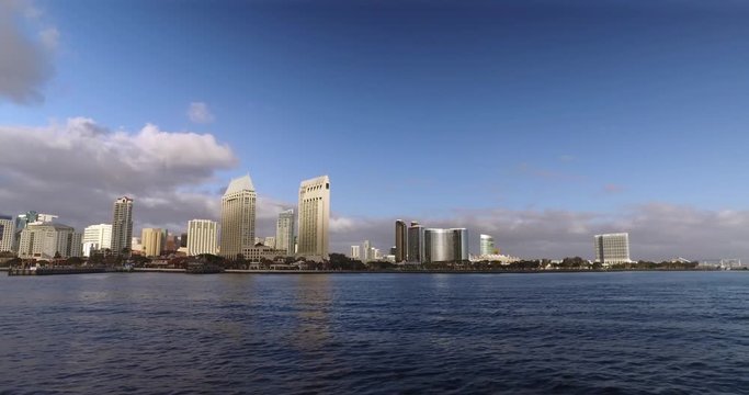 A wide, dramatic daytime establishing shot of the San Diego city skyline as seen from the bay.	 	