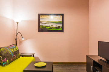 Interior living room with a sofa, large pillows, a small table and a floor lamp