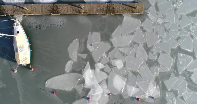 Ice blocks, Cinema 4k rising aerial of a boat and ice at a pier in the baltic sea, at a frosty winter day, in finnish archipelago of Taalintehdas, in Kemi&ouml;nsaari, Varsinais-suomi, Finland