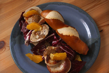 Laugenstange mit gebratener Gelbwurst, Orangen und Radicchio