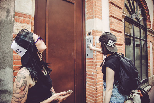 Attente de deux jeunes femmes devant la porte d'un immeuble